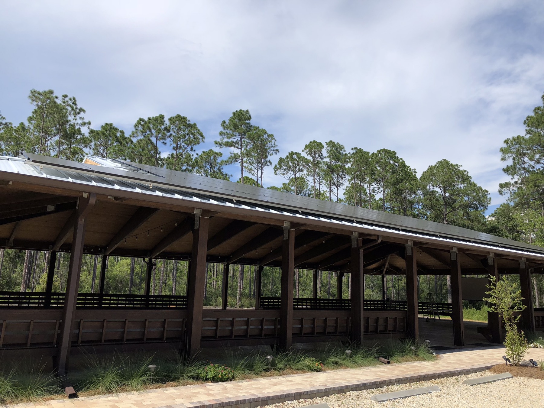 Curated exterior view of the Point Preserve pavilion framed by pines