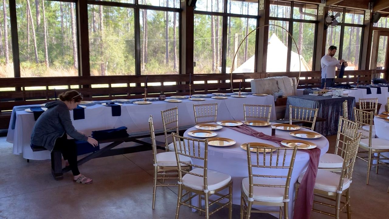 Guests seated for dinner under floral arrangements inside the pavilion