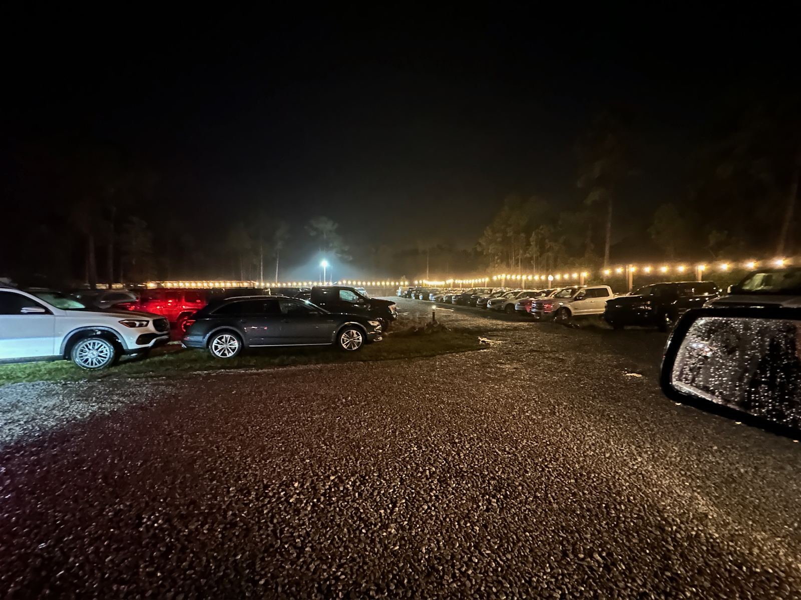 Evening arrival view showing the venue approach and parking