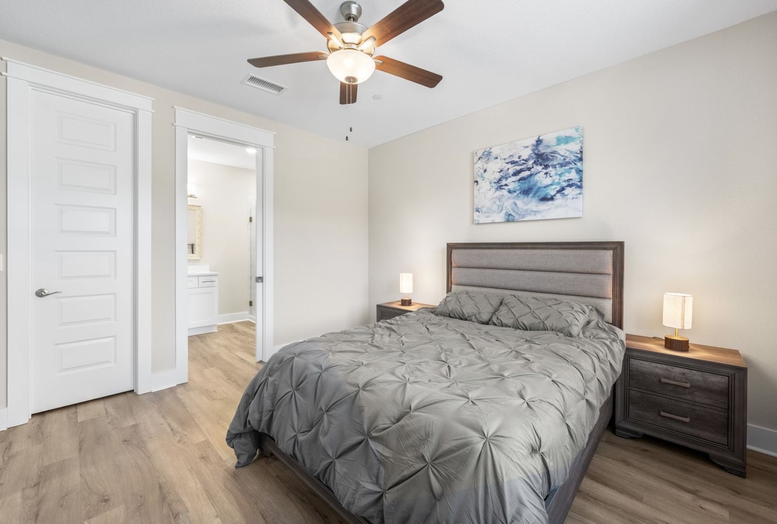 Primary bedroom with forest-view windows and ensuite access